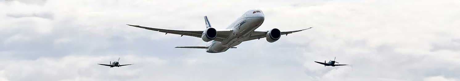 Three airplanes flying in formation in a clear blue sky.