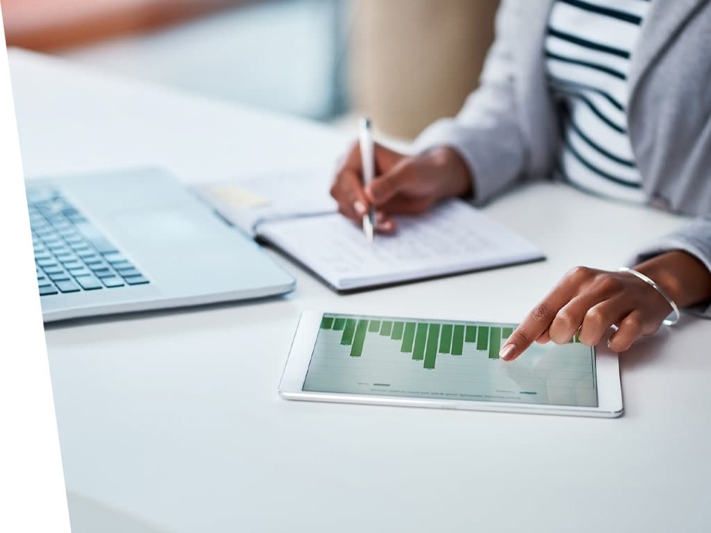 Women working on a moblie pad that has satisitcs on the screen.