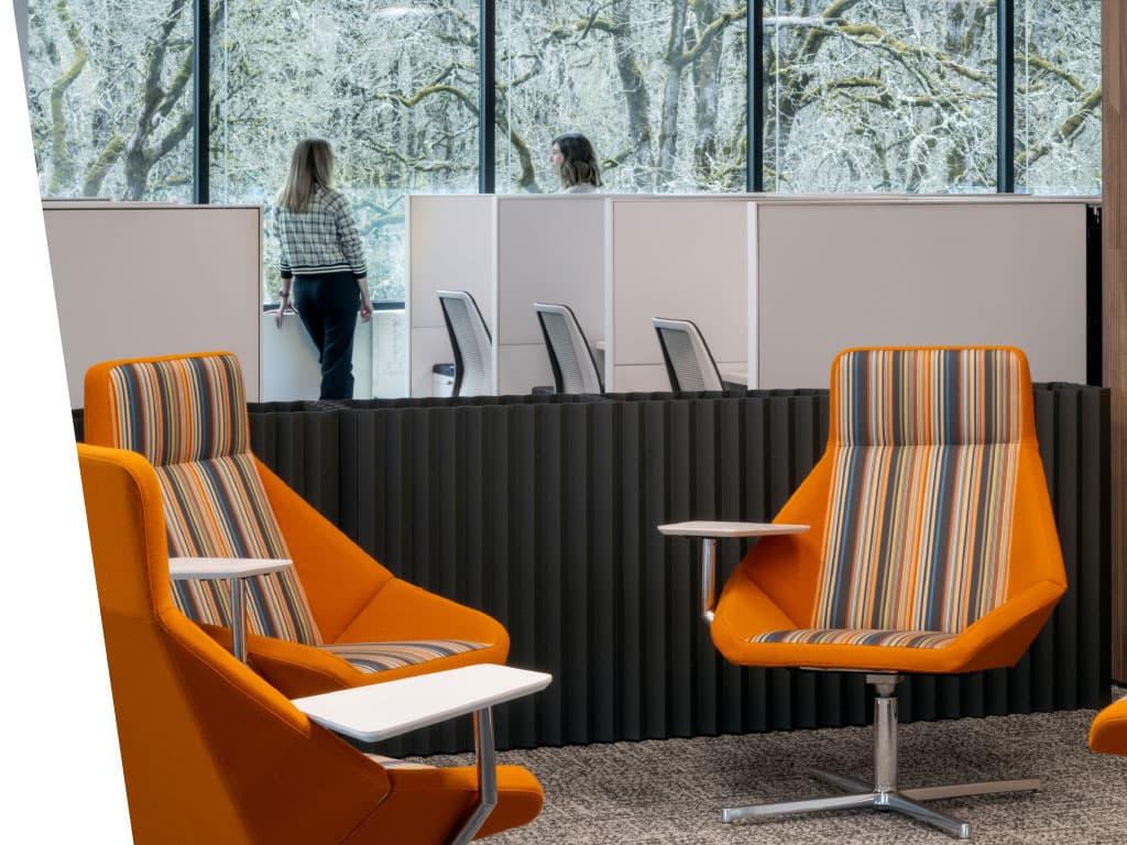 A group of chairs with armrests arranged in a room, featuring a window and designed flooring.