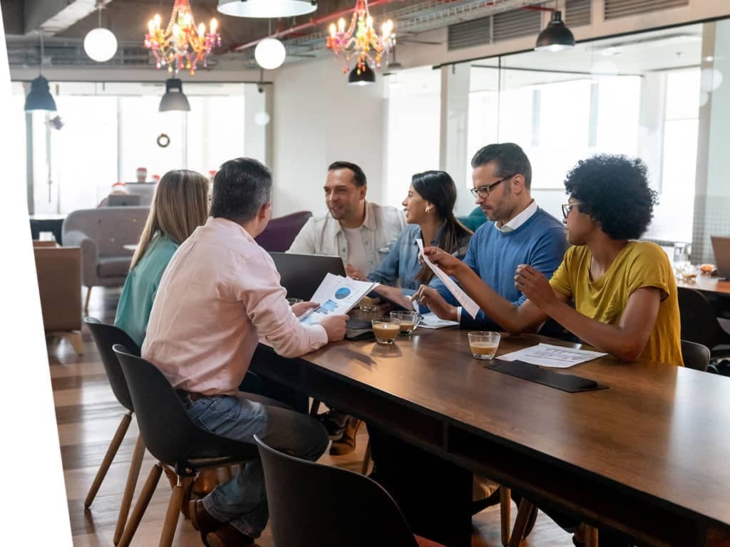 Diverse group of coworkers talking in a meeting room.