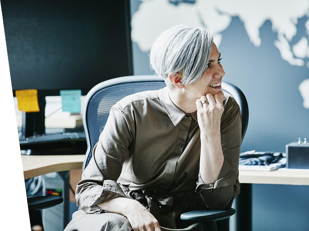Woman sitting at desk smiling in converstation.