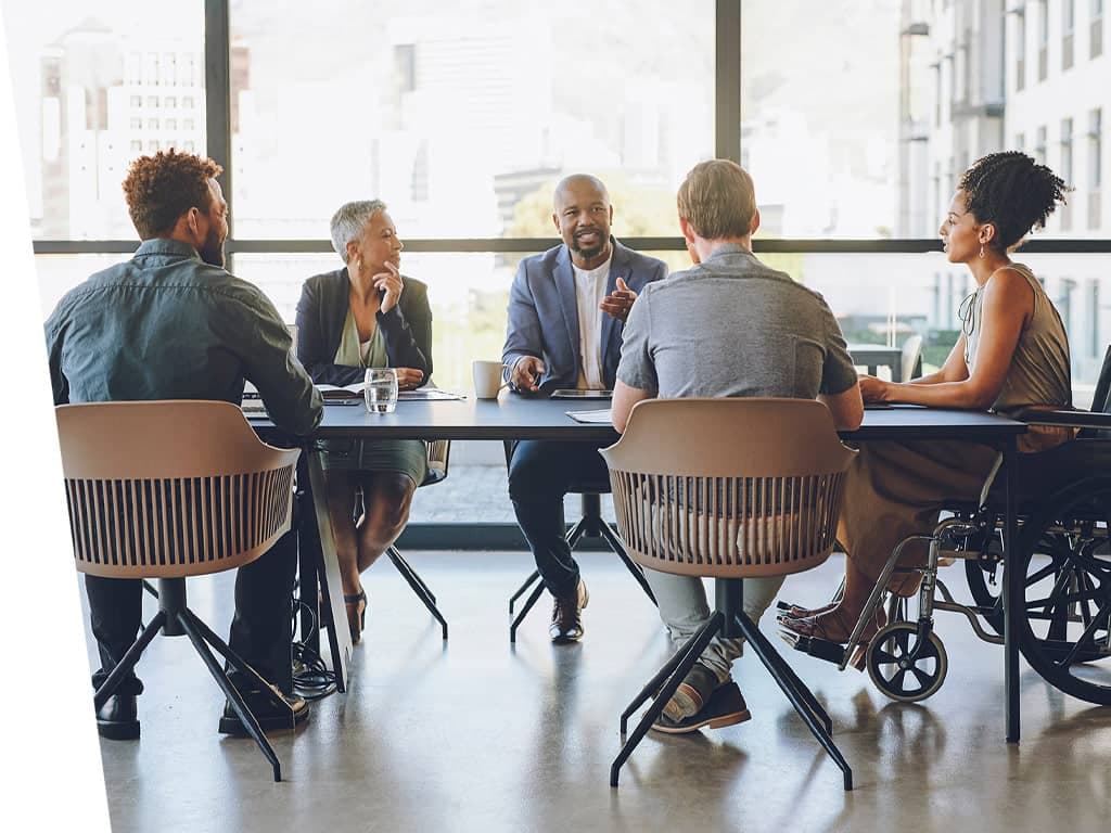 Diverse group of people in office meeting room.