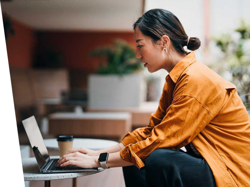 Woman working outside with a laptop.