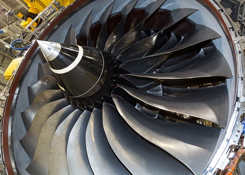A jet engine displayed in an airplane hangar.