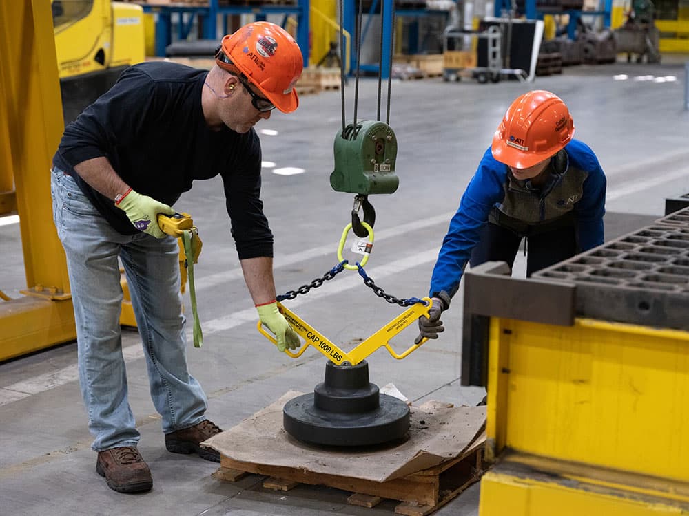 Two factory workers operating a machine.