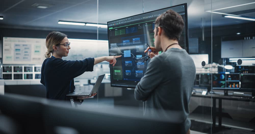 A man and a woman focused on a computer screen in a cozy room, sharing ideas and insights.
