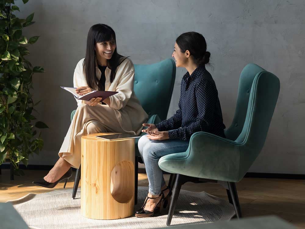 A group of individuals wearing hard hats and safety glasses, standing outdoors in workwear.