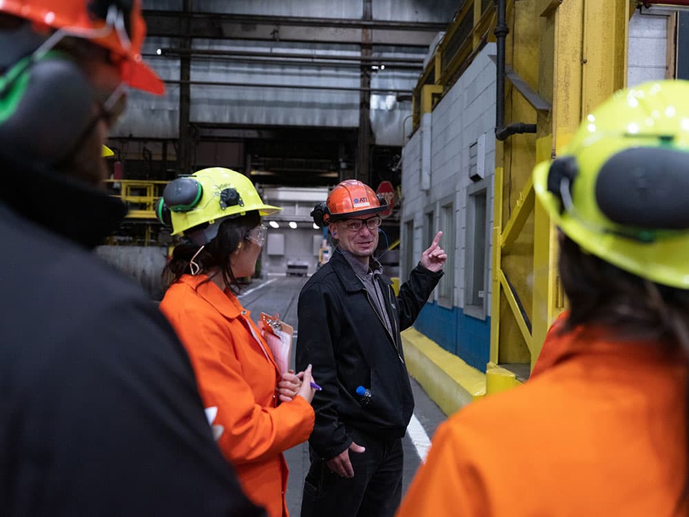 A team of workers equipped with hard hats and safety glasses, prepared for tasks in a construction or industrial area.